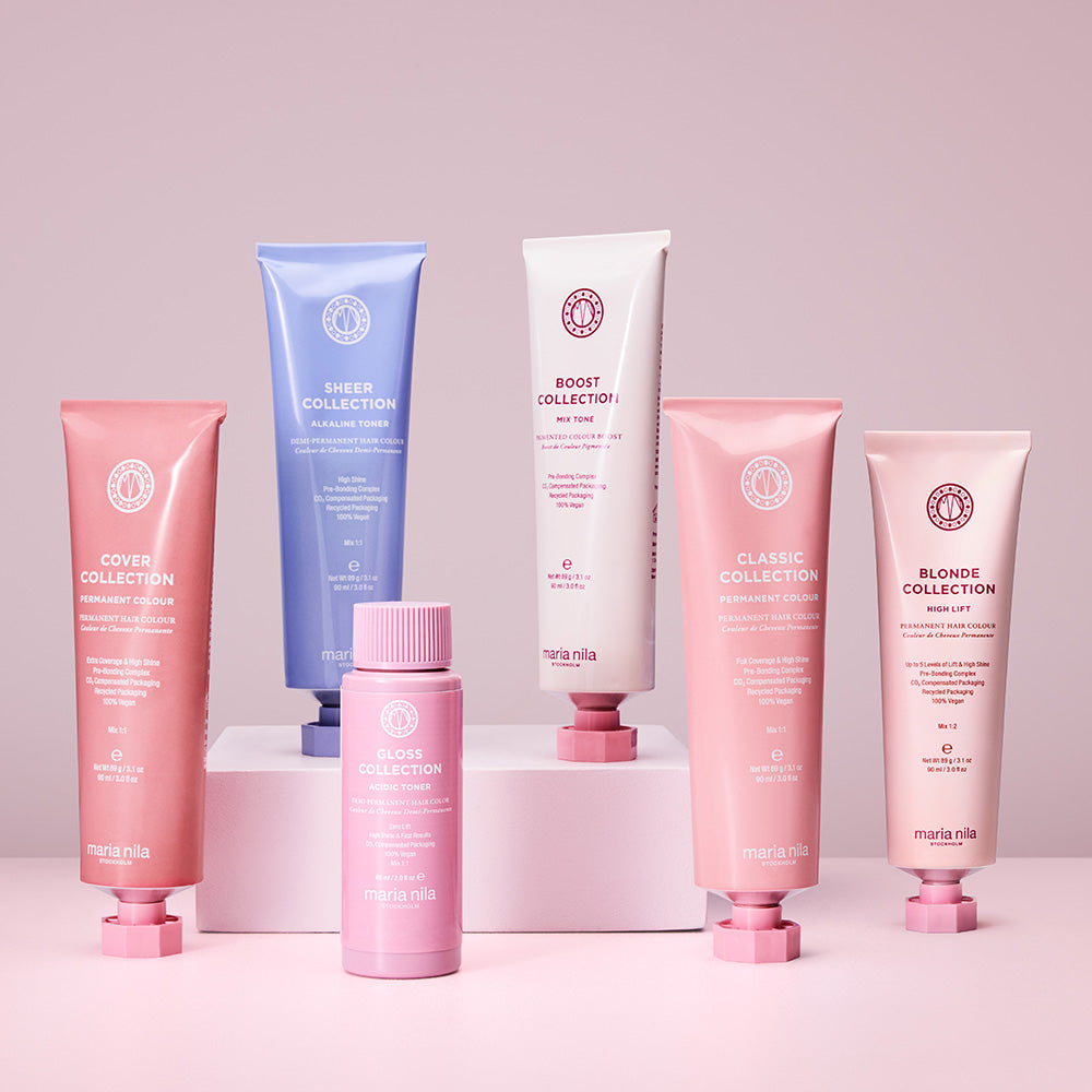Collection of Maria Nila hair care products on a pink background